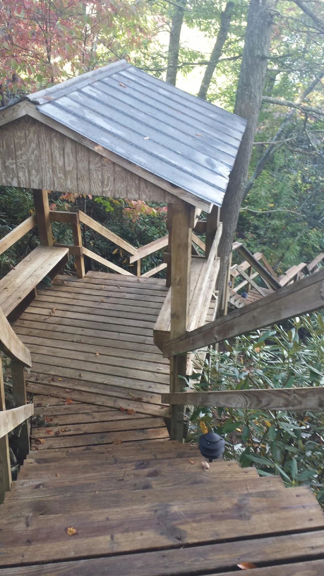 Metal roofed shelter over wooden steps on a wooded walkway — Skylight Repair & Installation work by our crew in Churdan