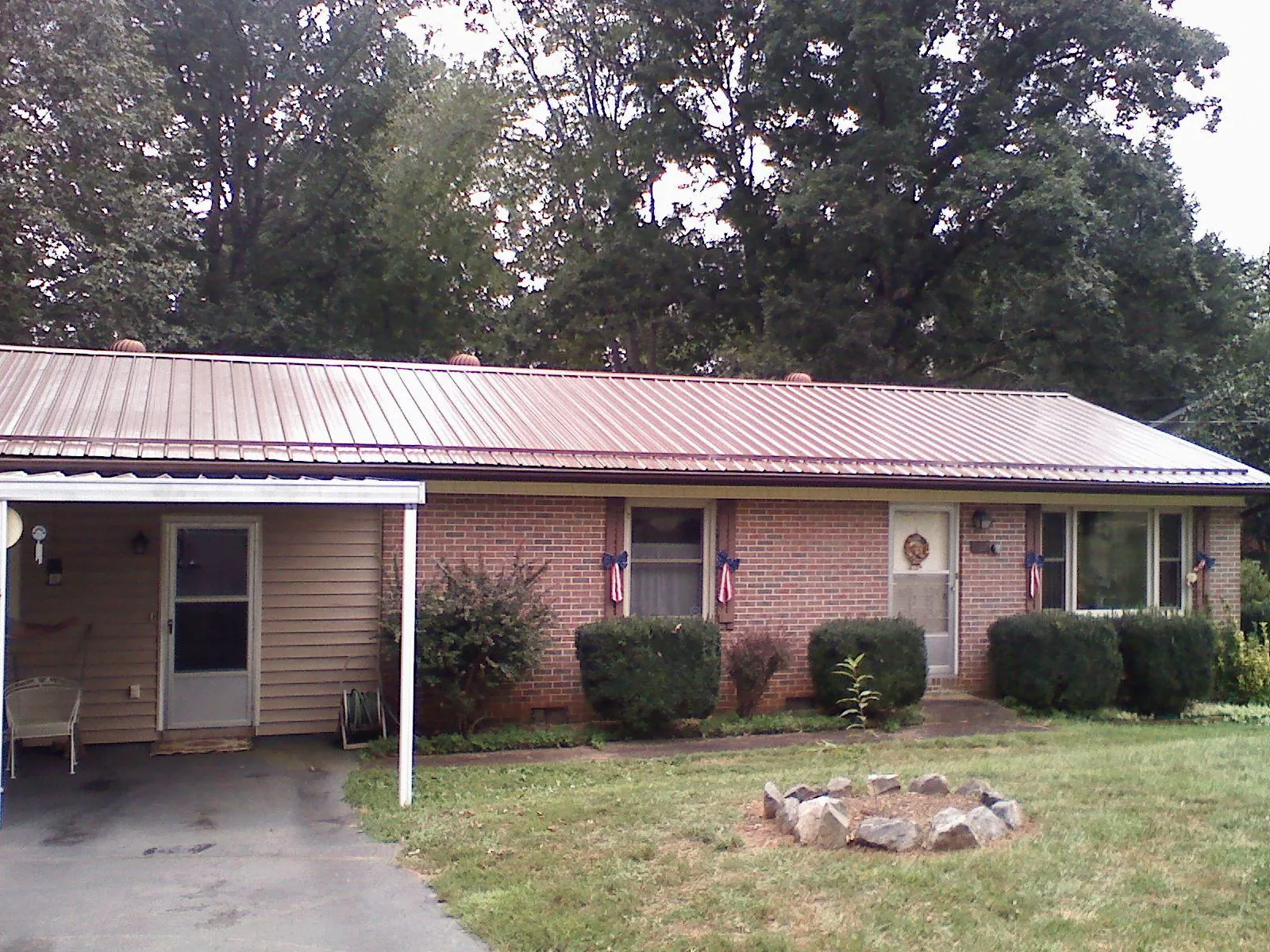 Bronze metal roof and carport on a brick ranch home — Roof Repair work by our crew in Churdan